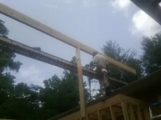 Carpenter setting a ridge beam over a new addition frame — Ice Dam Removal by Roofing Brothers in Beach Lake