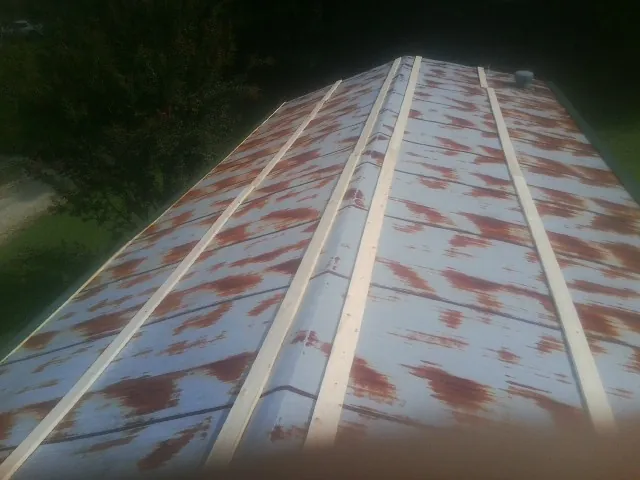 Rusted metal roof panels with new wood purlins before replacement — Storm Damage Roof Repair in Beach Lake by Roofing Brothers