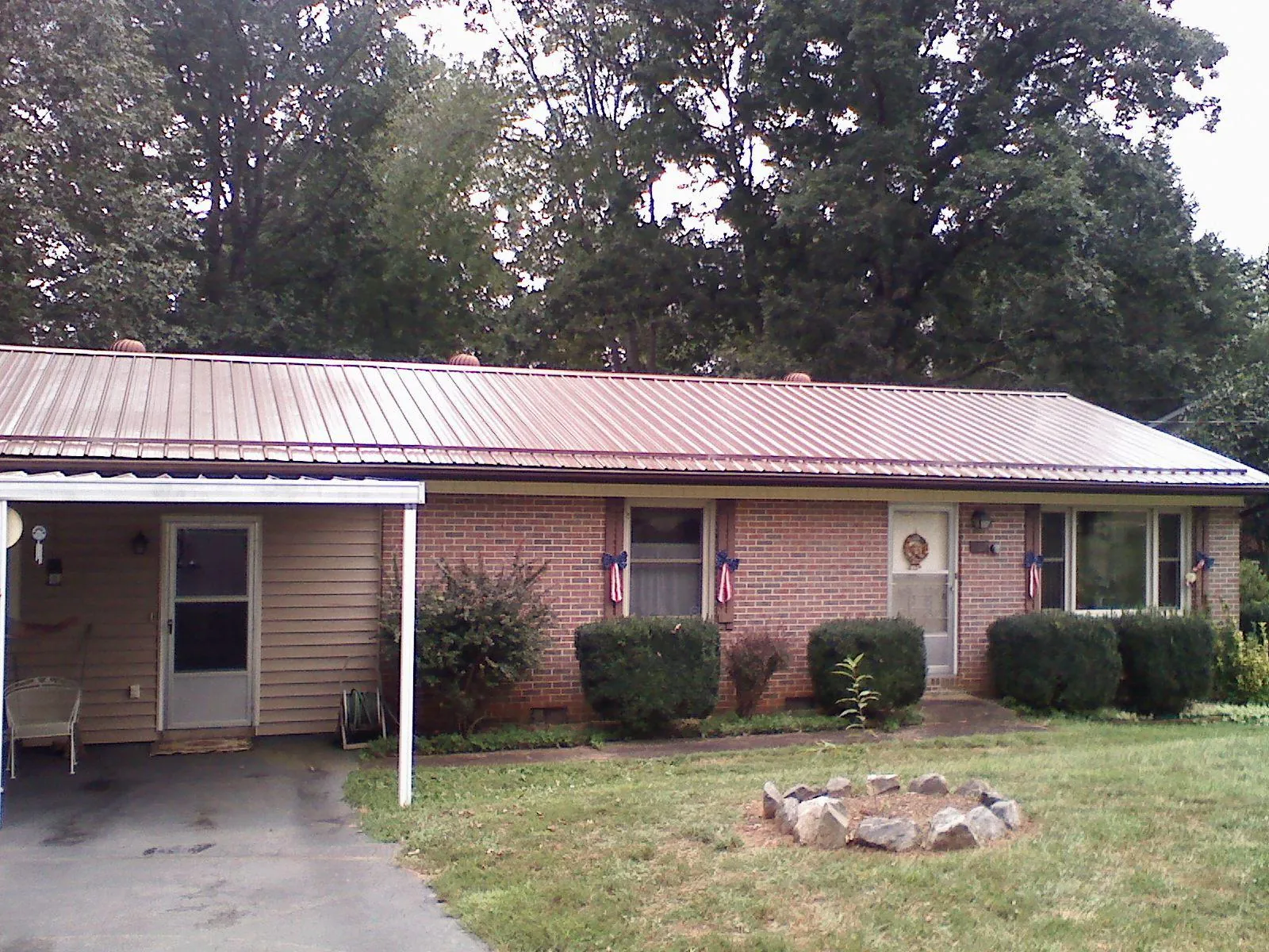 Bronze metal roof and carport on a brick ranch home — Roof Repair work by our crew in Beach Lake